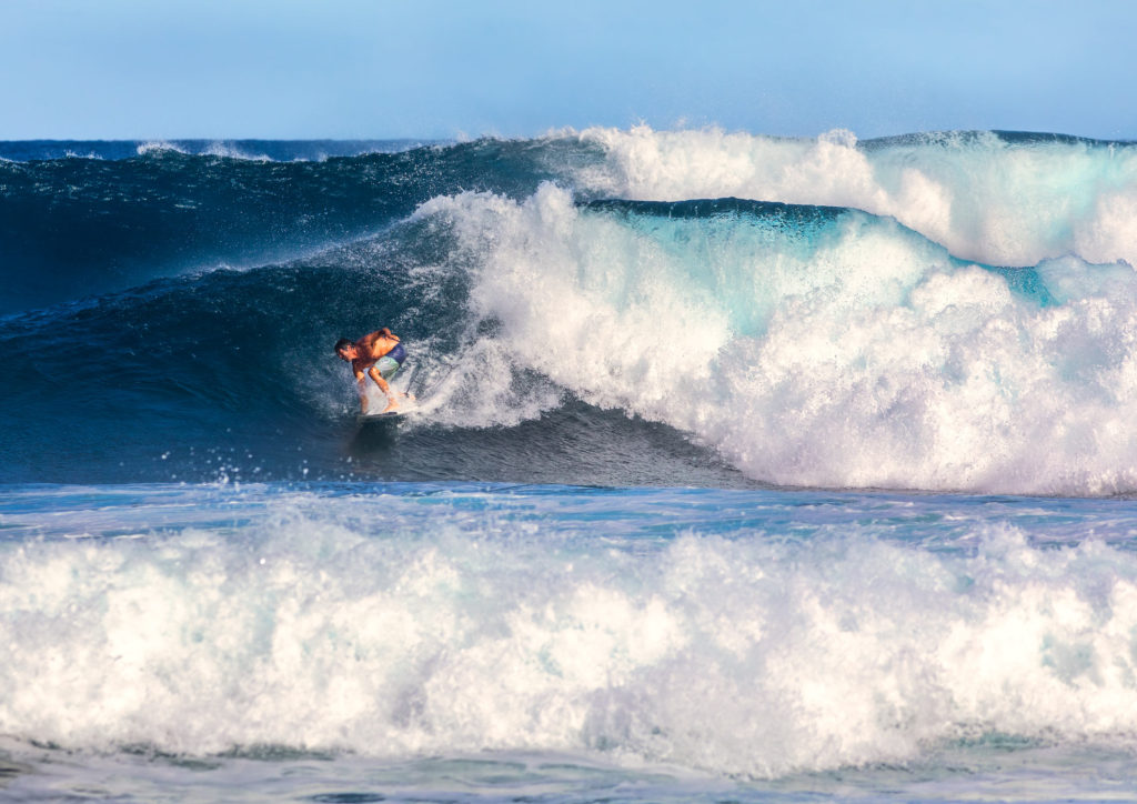 surfer in Maui Hawaii on huge blue wave