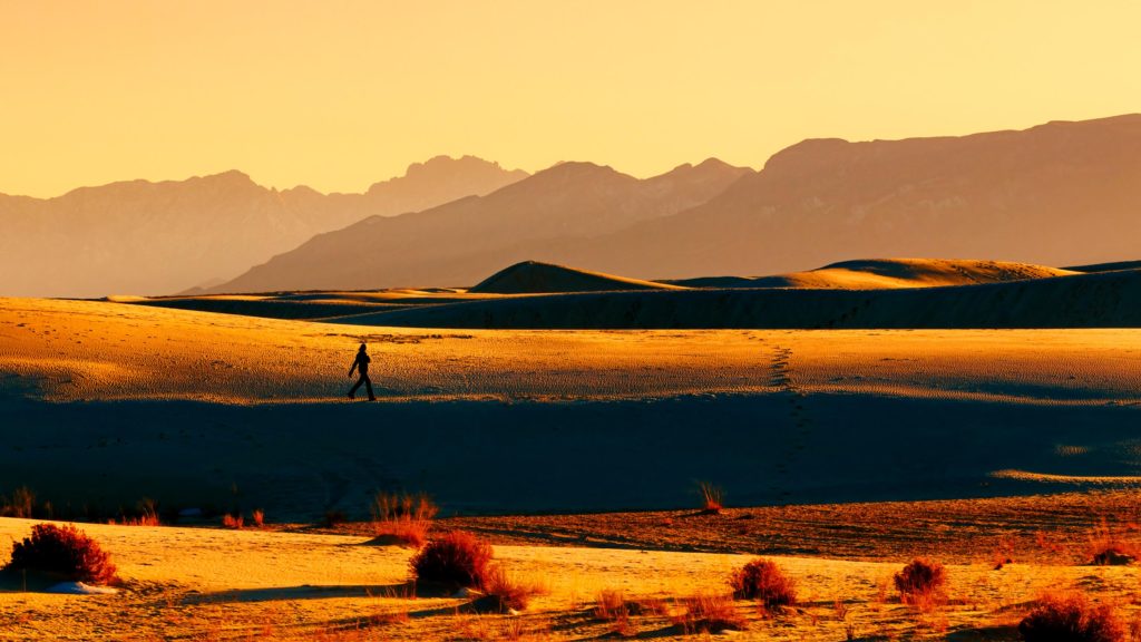 A lone person walks on the dunes at sunset at White Sands NP